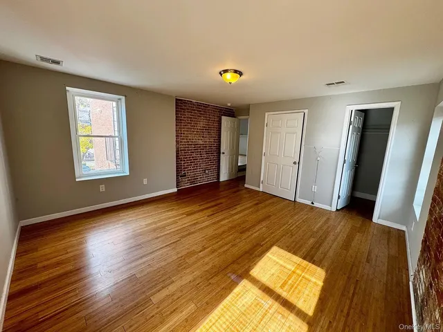 a view of a room with wooden floor and windows