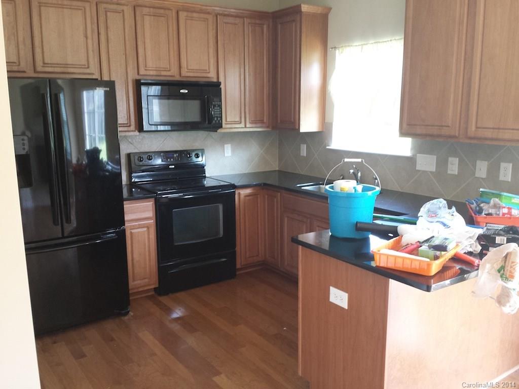 4084 Clover Road Northwest Concord, NC 28027 - Photo 2 of 17 a kitchen with stainless steel appliances granite countertop a refrigerator stove a sink and dishwasher with wooden floor
