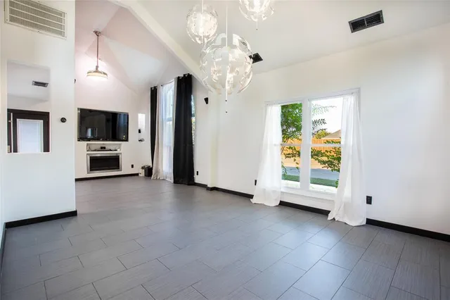 a view of an empty room with a fireplace and a window