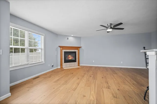 an empty room with a fireplace and windows