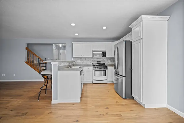 a kitchen with a refrigerator a sink and a stove top oven