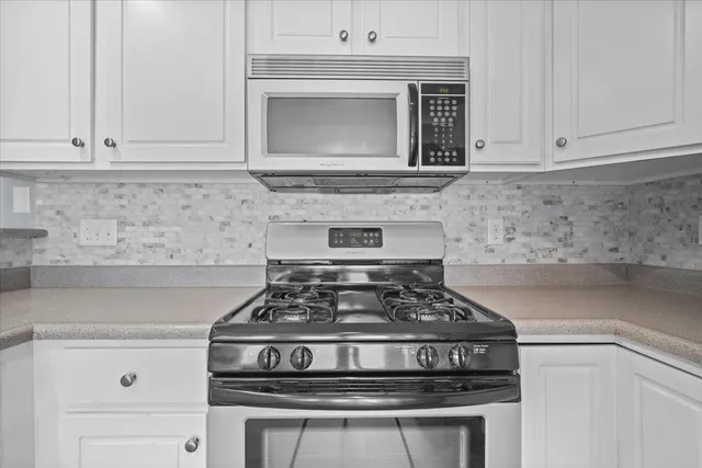 a stove top oven sitting inside of a kitchen