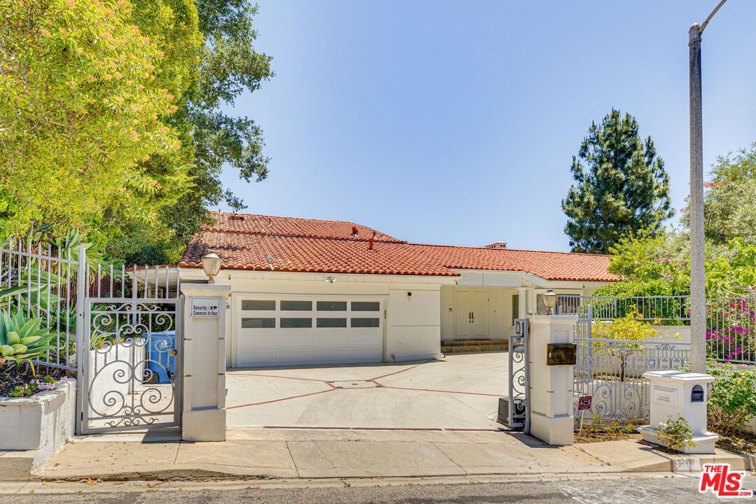 1410 Stradella Road Los Angeles, CA 90077 - Photo 2 of 42 a front view of a house with a garden