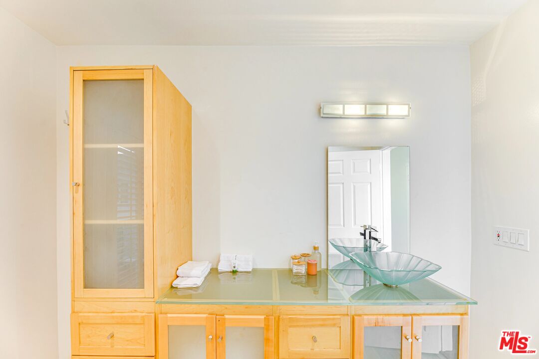 1410 Stradella Road Los Angeles, CA 90077 - Photo 27 of 42 a bathroom with a granite countertop sink and a mirror