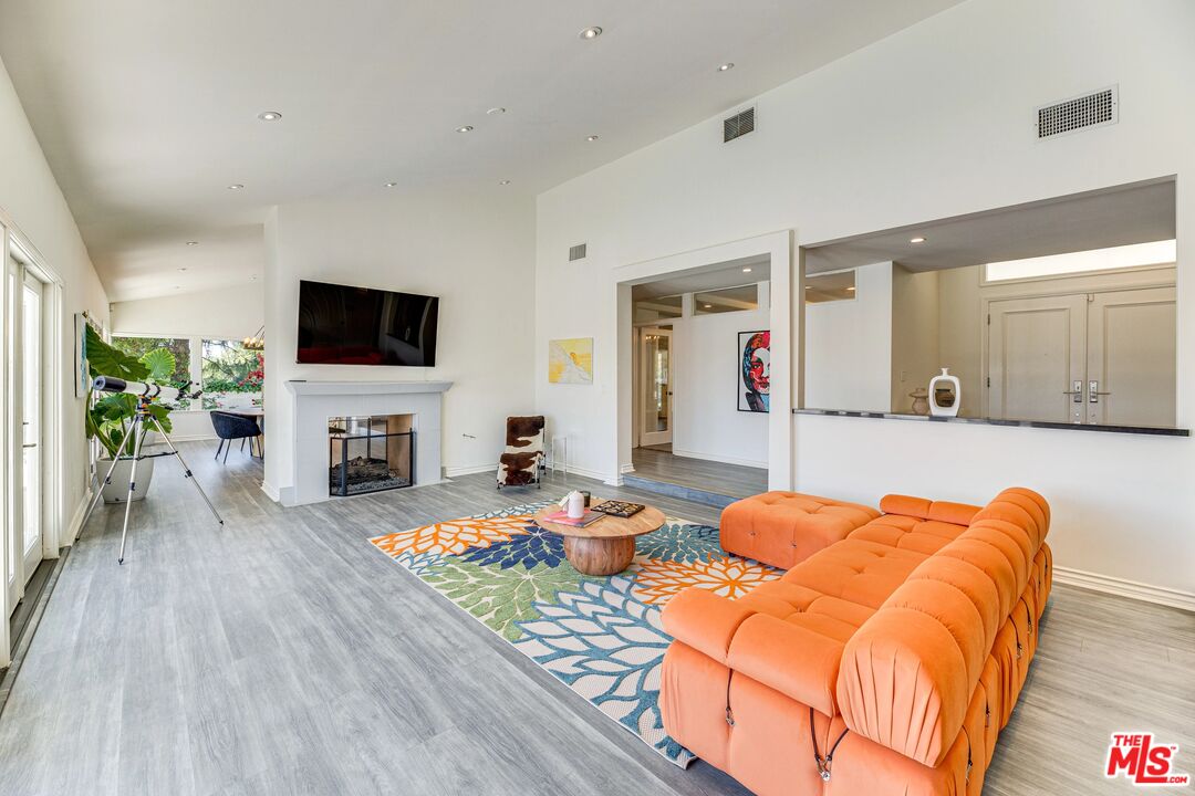 1410 Stradella Road Los Angeles, CA 90077 - Photo 3 of 42 a bedroom with furniture and a flat screen tv