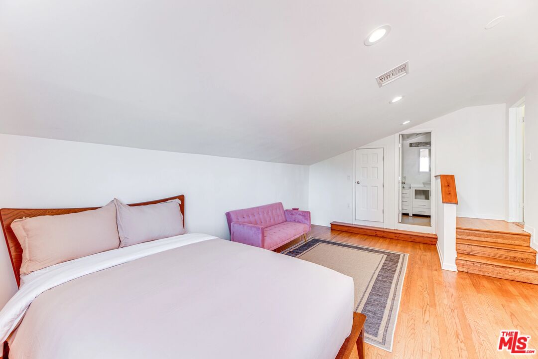 1410 Stradella Road Los Angeles, CA 90077 - Photo 32 of 42 a bedroom with a bed and wooden floor