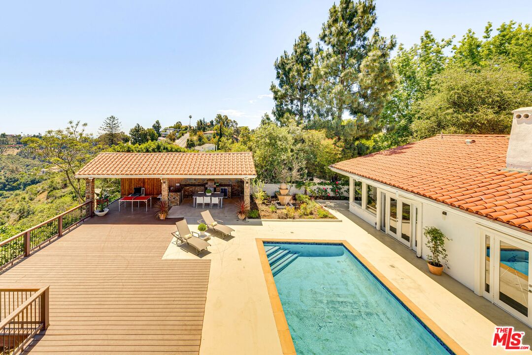 1410 Stradella Road Los Angeles, CA 90077 - Photo 39 of 42 a view of a swimming pool with seating area and trees around