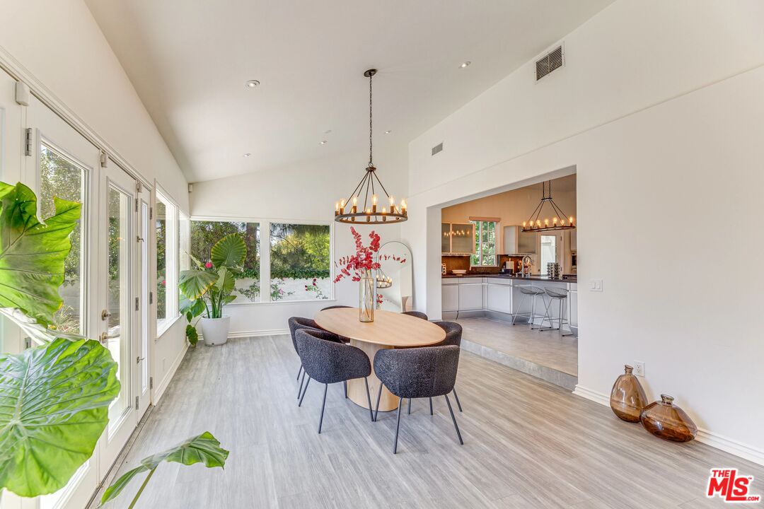 1410 Stradella Road Los Angeles, CA 90077 - Photo 9 of 42 a dining room with furniture a chandelier and wooden floor