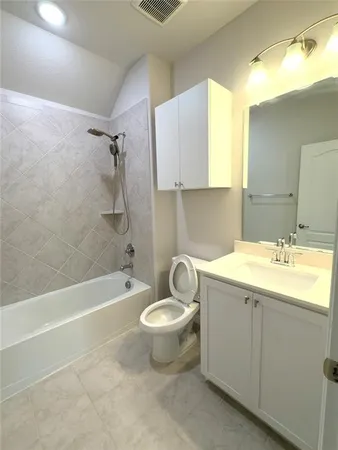 a bathroom with a granite countertop sink toilet and bathtub