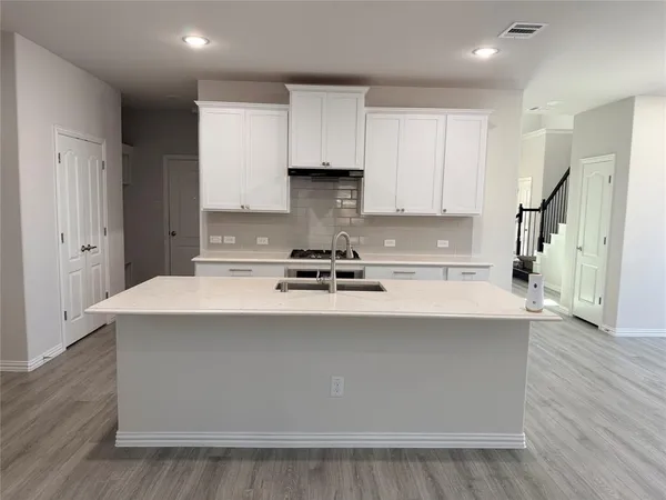 a kitchen with stainless steel appliances a white stove top oven sink and cabinets
