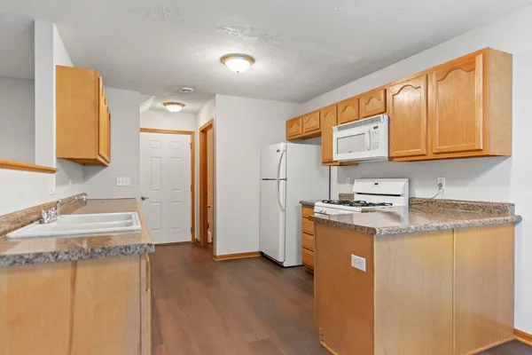 a kitchen with stainless steel appliances granite countertop a refrigerator a stove a sink and a microwave