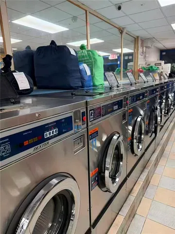 a utility room with stainless steel appliances granite countertop lots of clutter