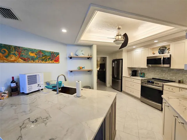 a kitchen with stainless steel appliances kitchen island granite countertop a sink and cabinets