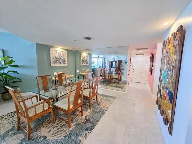 a dining room with furniture and a floor to ceiling window