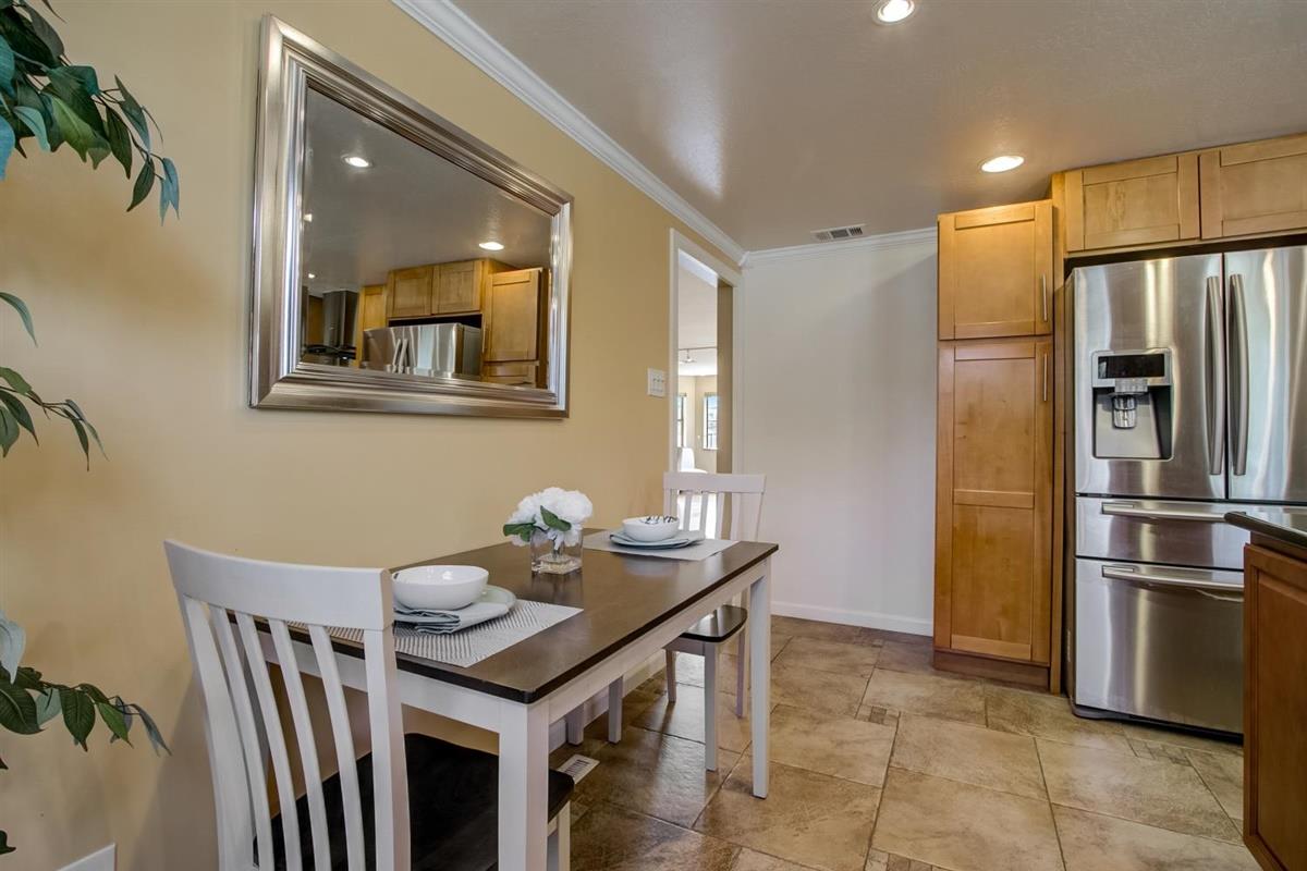 38061 Blacow Road Fremont, CA 94536 - Photo 21 of 65 a kitchen with stainless steel appliances granite countertop a dining table chairs and refrigerator