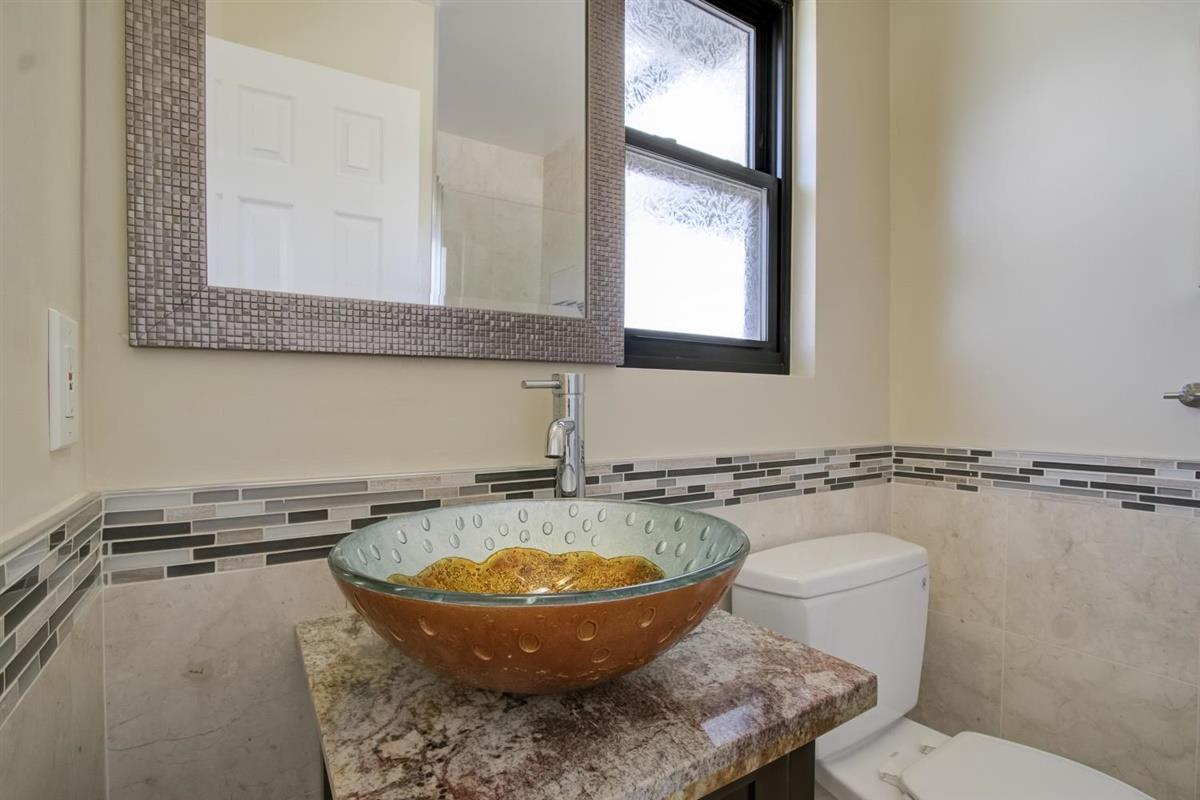 38061 Blacow Road Fremont, CA 94536 - Photo 47 of 65 a bathroom with a toilet a sink and mirror