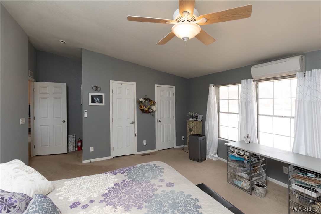 1464 South Dragoon Road Golden Valley, AZ 86413 - Photo 14 of 47 a bedroom with a large bed and a chandelier