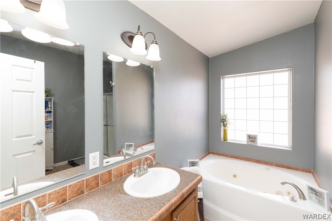 1464 South Dragoon Road Golden Valley, AZ 86413 - Photo 15 of 47 a bathroom with a tub sink and mirror