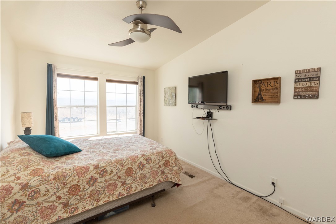 1464 South Dragoon Road Golden Valley, AZ 86413 - Photo 18 of 47 a bedroom with a bed mirror and a window