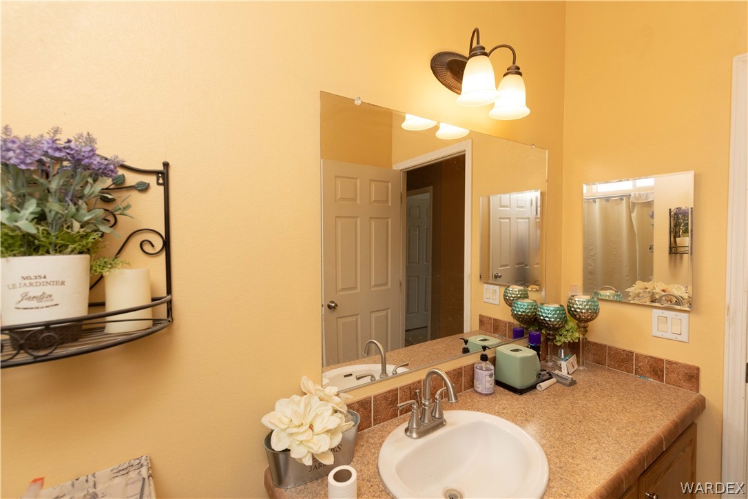 1464 South Dragoon Road Golden Valley, AZ 86413 - Photo 21 of 47 a bathroom with a granite countertop sink and a mirror