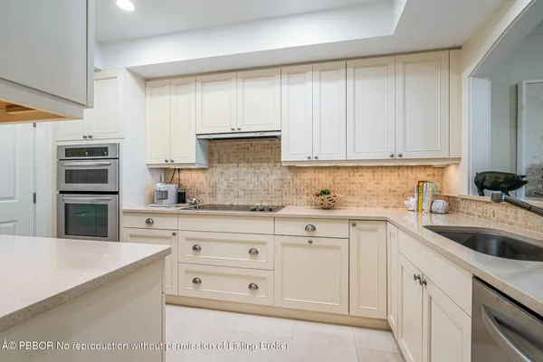 a kitchen with cabinets appliances a sink and a counter top space