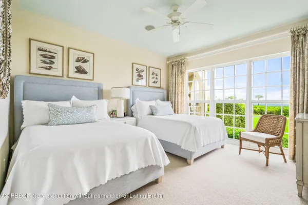 a bedroom with two beds and a large window