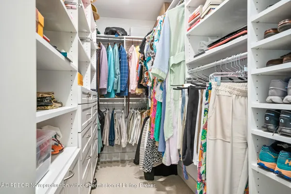 a view of walk in closet with clothes and shoes