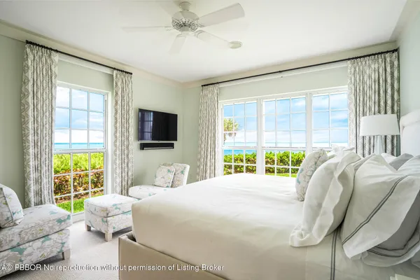 a bedroom with a bed television and a large window