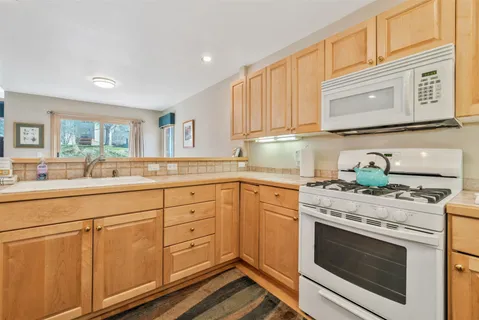 a kitchen with granite countertop cabinets stainless steel appliances and a counter space