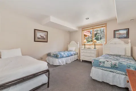 a bedroom with two beds and painting on the wall