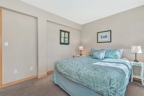 a bedroom with a bed and a painting on the wall