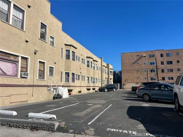 a city street lined with buildings and a cars parked on the street