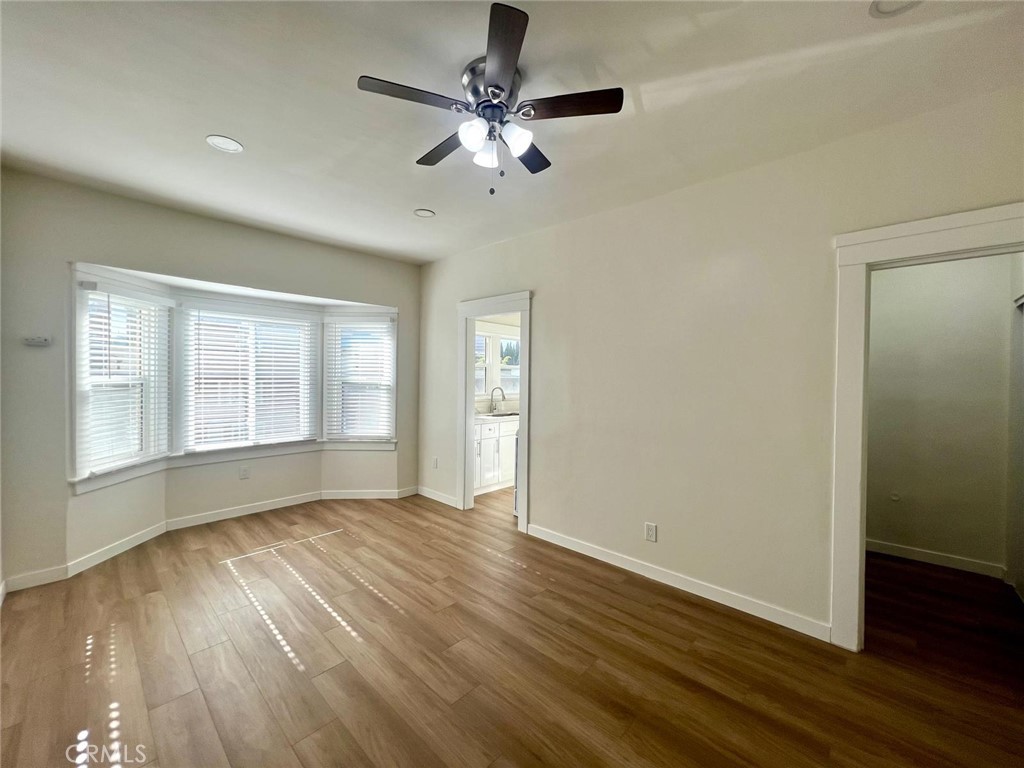 354 Chestnut Avenue, Unit 29 Long Beach, CA 90802 - Photo 3 of 19 an empty room with wooden floor chandelier fan and windows