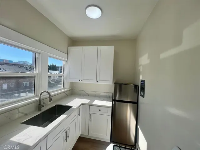 a kitchen with a refrigerator sink and cabinets
