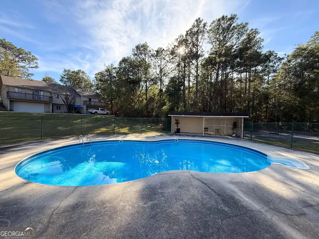 a view of a swimming pool with an outdoor seating and a forest
