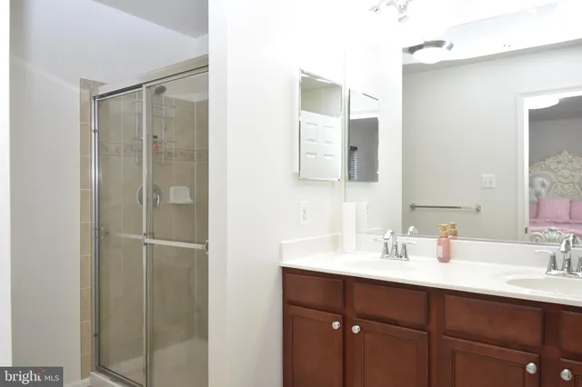 a bathroom with a shower sink vanity and mirror