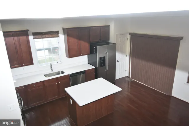 a kitchen with a sink a refrigerator and wooden cabinets
