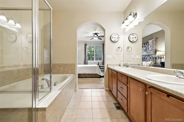 a spacious bathroom with a tub sink and a mirror
