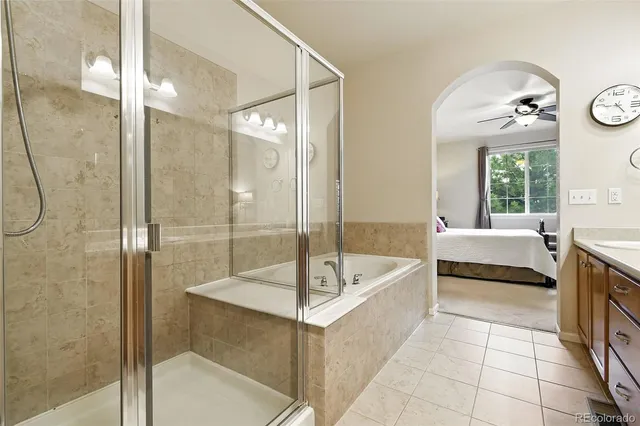 a spacious bathroom with a tub shower and mirror
