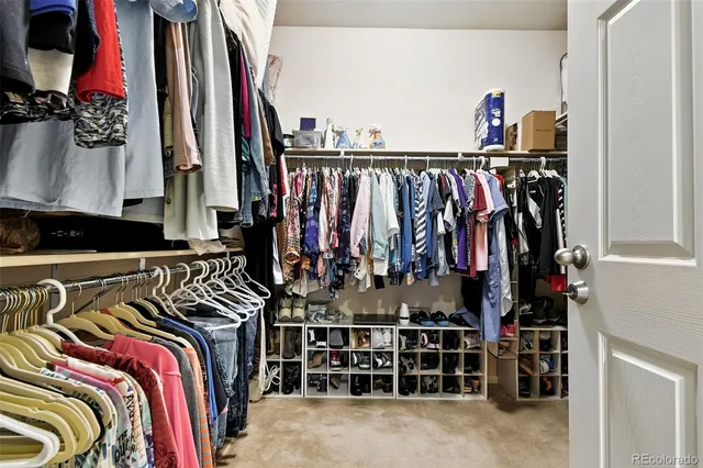 a view of walk in closet with clothes and shoes