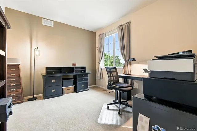 a view of a workspace with furniture and a window