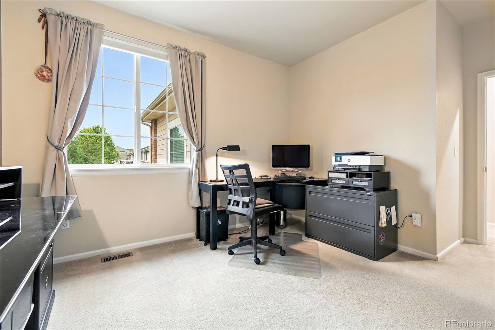 12804 Harrison Street Thornton, CO 80241 - Photo 28 of 37 a view of a workspace with furniture and a window