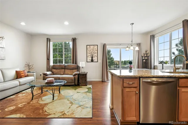 a living room with furniture a large window and a dining table