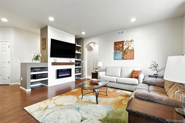 a living room with furniture a flat screen tv and a fireplace