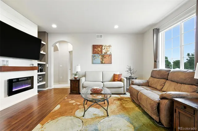 a living room with furniture a flat screen tv and a fireplace