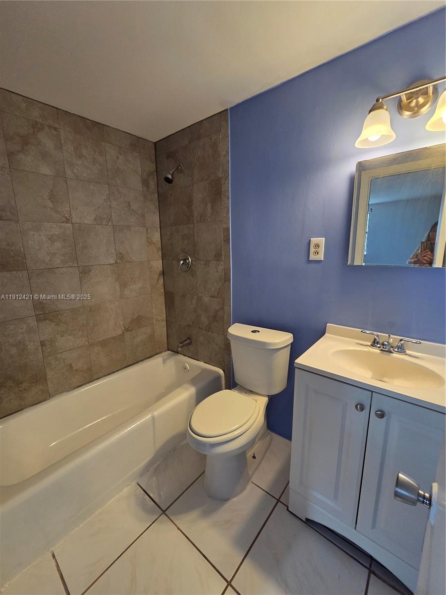 2124 South Beech Road, Unit B West Palm Beach, FL 33409 - Photo 12 of 12 a bathroom with a granite countertop toilet a sink and bathtub