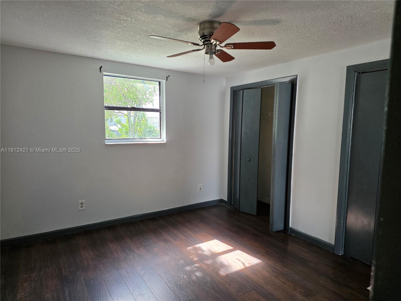 2124 South Beech Road, Unit B West Palm Beach, FL 33409 - Photo 7 of 12 an empty room with wooden floor and windows
