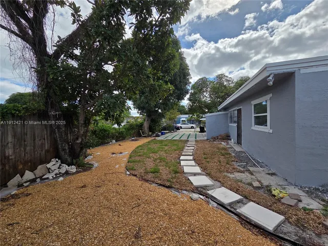 a view of a yard with wooden fence