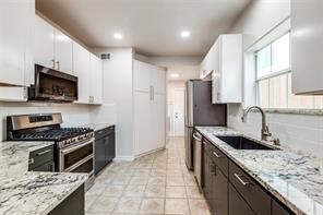 1318 Peden Street, Unit D Houston, TX 77006 - Photo 7 of 33 a kitchen with stainless steel appliances granite countertop a sink stove microwave and refrigerator