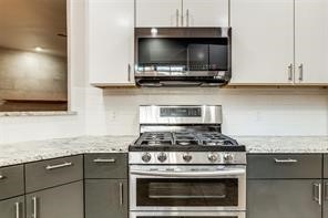 1318 Peden Street, Unit D Houston, TX 77006 - Photo 9 of 33 a kitchen with granite countertop a stove and a microwave